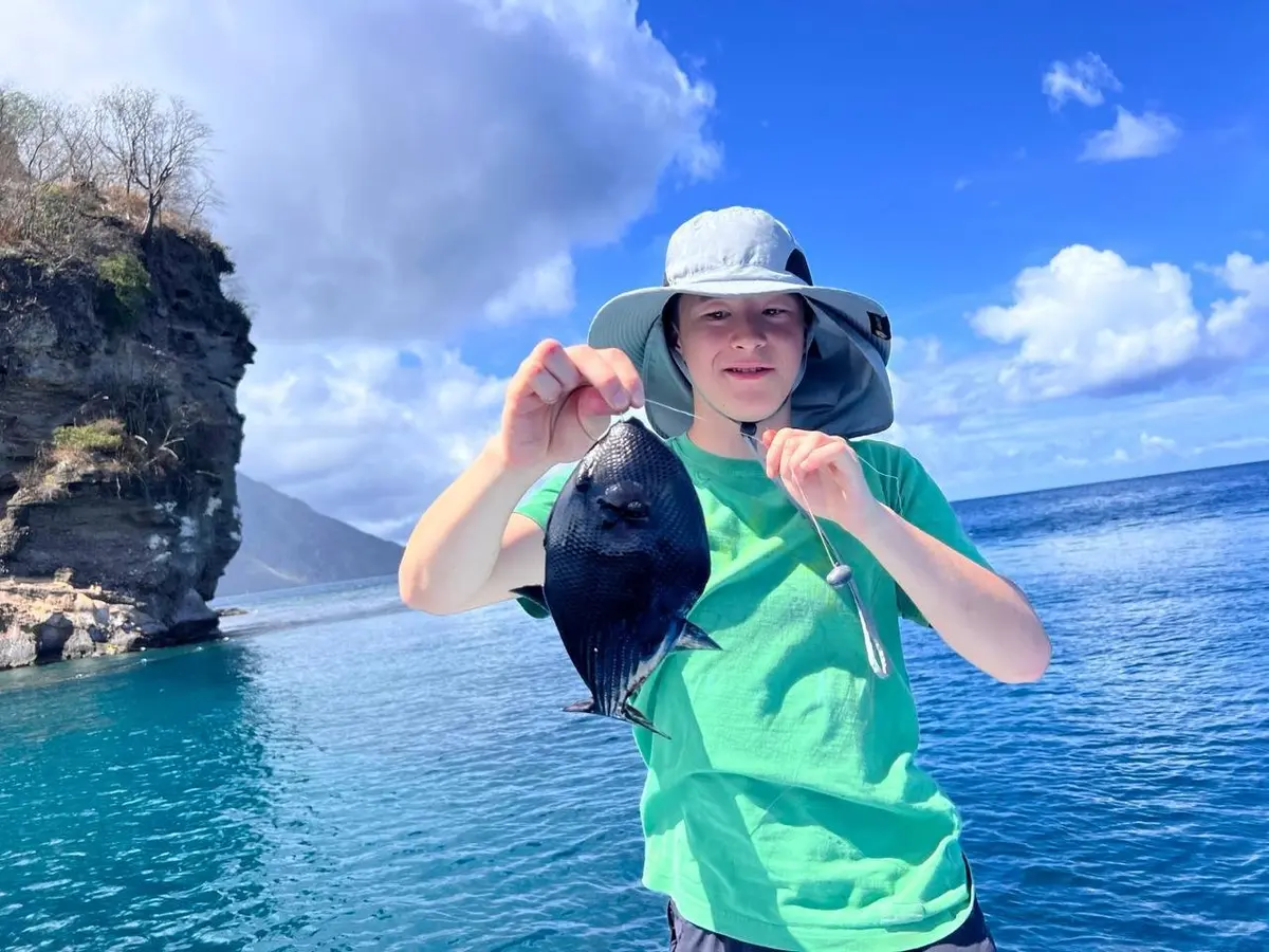 Young guest holding a sea find on a St. Lucia boat trip